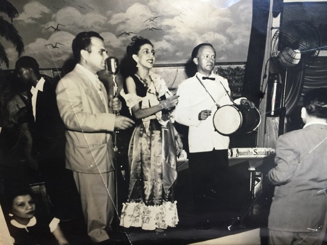 Dominican dancer Lucy Saladín and folklorist José G. Ramírez Peralta playing tambora with Juanito Sanabria Orchestra, ca. late 1940s