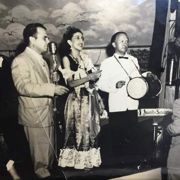 Dominican dancer Lucy Saladín and folklorist José G. Ramírez Peralta playing tambora with Juanito Sanabria Orchestra, ca. late 1940s
