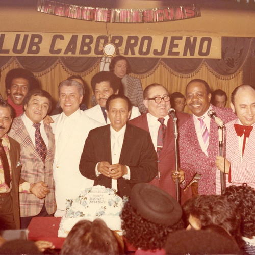 Birthday party for Puerto Rican promoter Federico Pagani at El Caborrojeño featuring from left to right: Ismael Quintana, Roberto Roena, Tito Puente, Yoyito Cabrera, Federico Pagani, Gaspar Pumarejo, Alberto Beltran, and Primitivo Santos,  1970s.